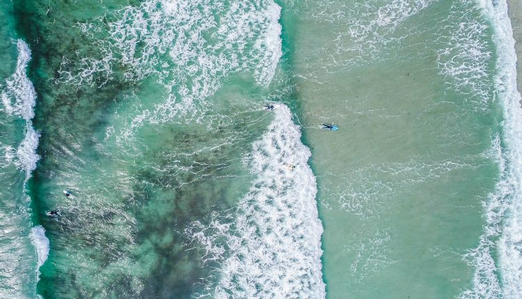 surfers rugged beach